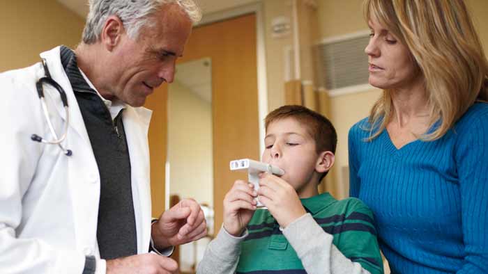 profesional de la salud ayudando a un niño con un producto para el asma