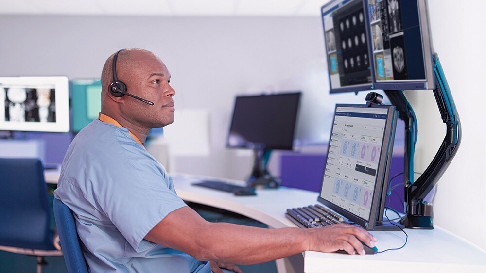 A radiology technologist monitoring exams remotely