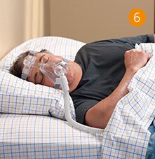 un hombre y una mujer acostados en la cama con una máscara de oxígeno